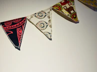 A collection of finished flags displayed against a rustic wooden wall, each telling its own story.