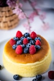 A cozy kitchen scene showing a baker carefully decorating a cheesecake with fresh berries.