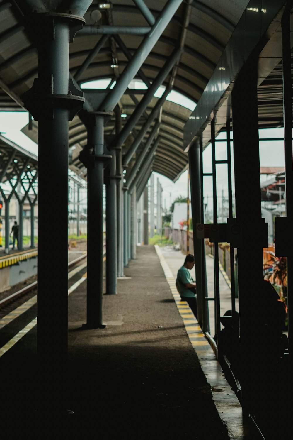 a person sitting on a bench at a train station