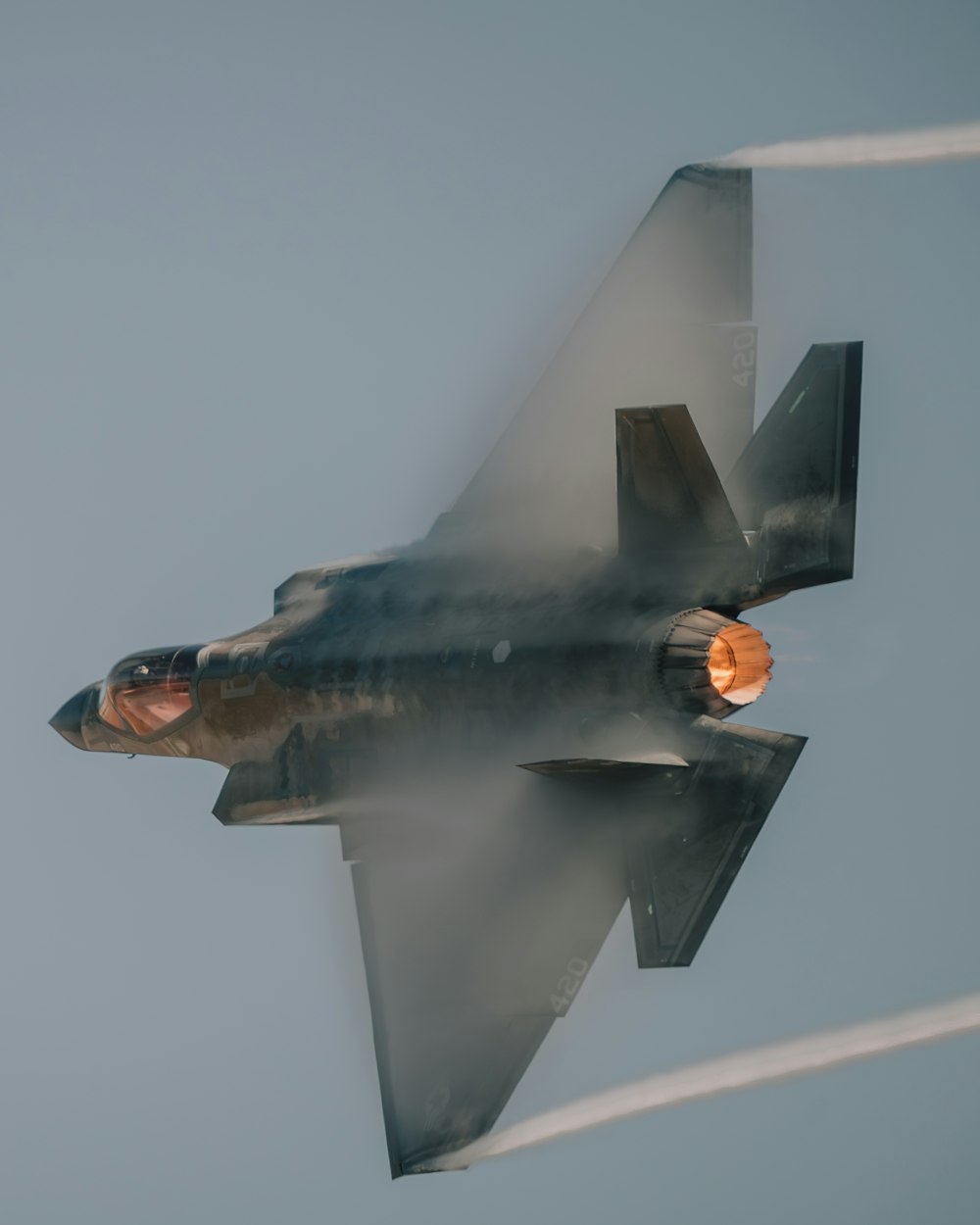 a fighter jet flying through the air with smoke coming out of it