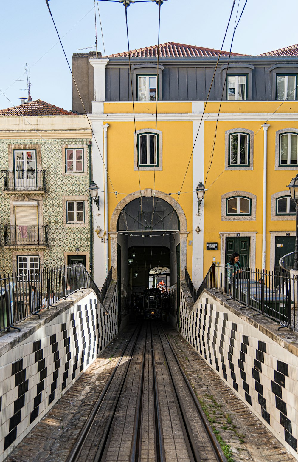 a train traveling through a tunnel next to a tall yellow building