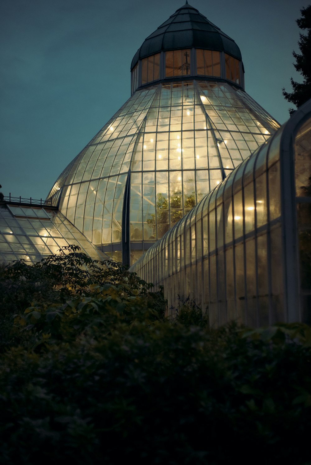 a large glass building with lights inside of it