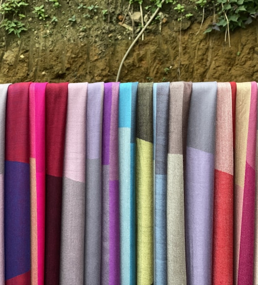 a row of colorful towels hanging on a clothes line