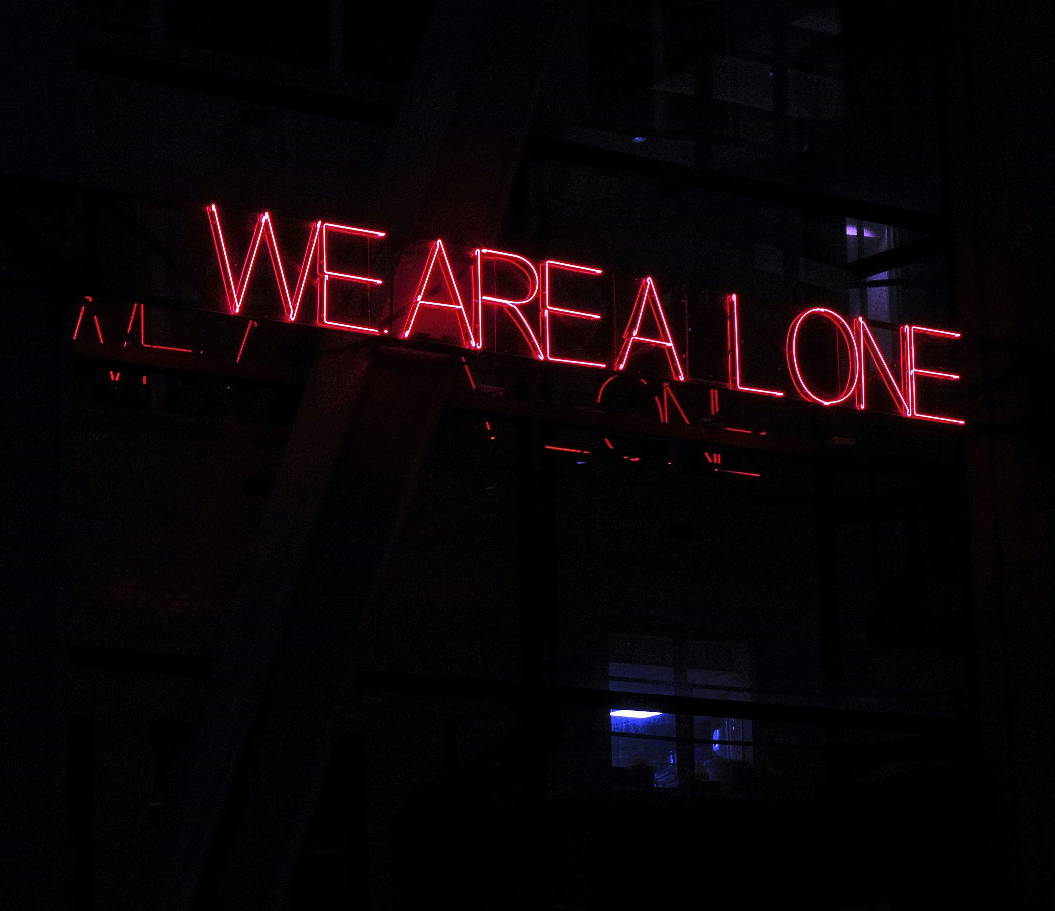 tanda neon yang bertuliskan kita sendirian