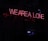 Red neon text saying 'WE ARE ALL ONE' in uppercase letters against a dark background. The sign is positioned diagonally.