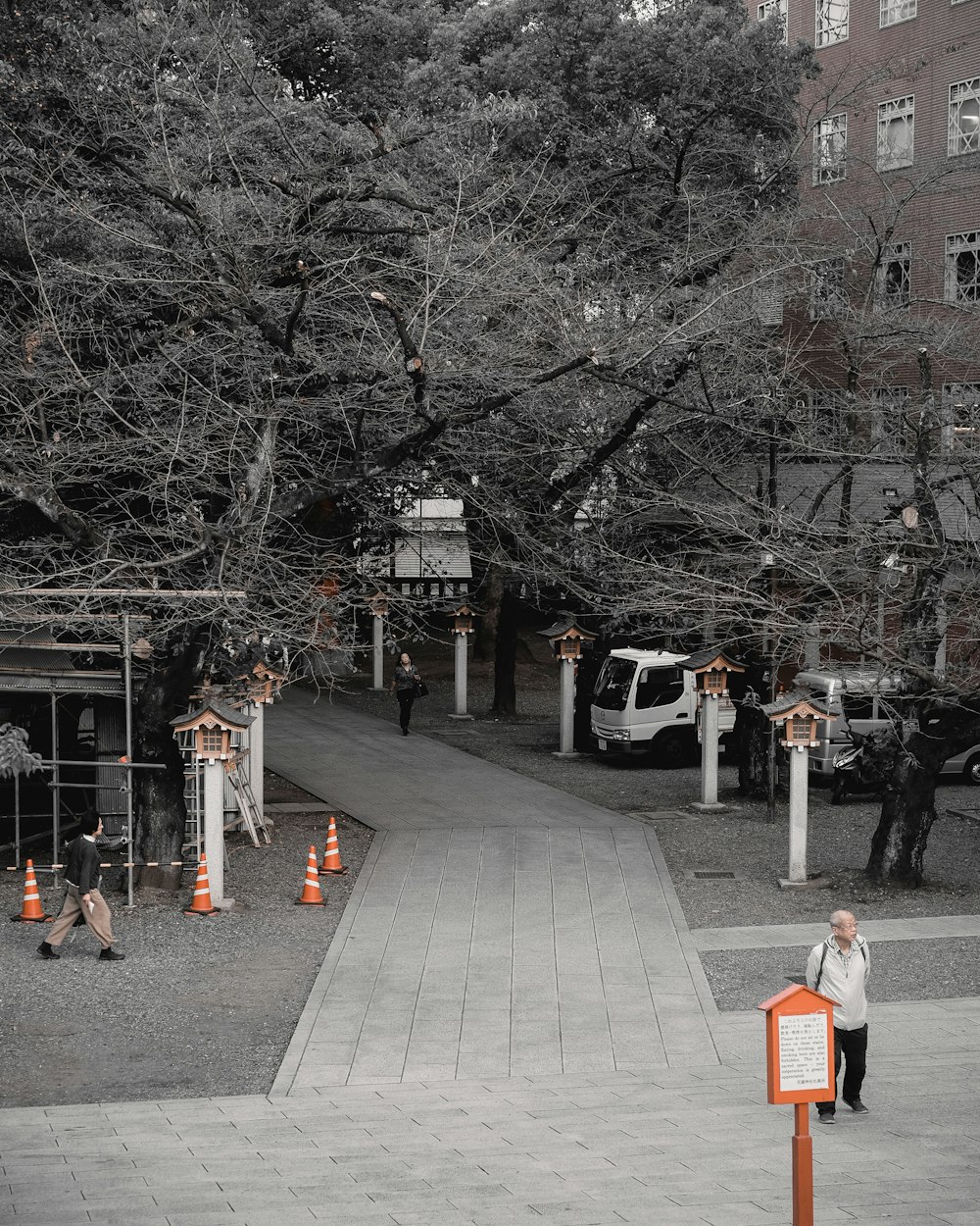 a black and white photo of a man standing on a sidewalk