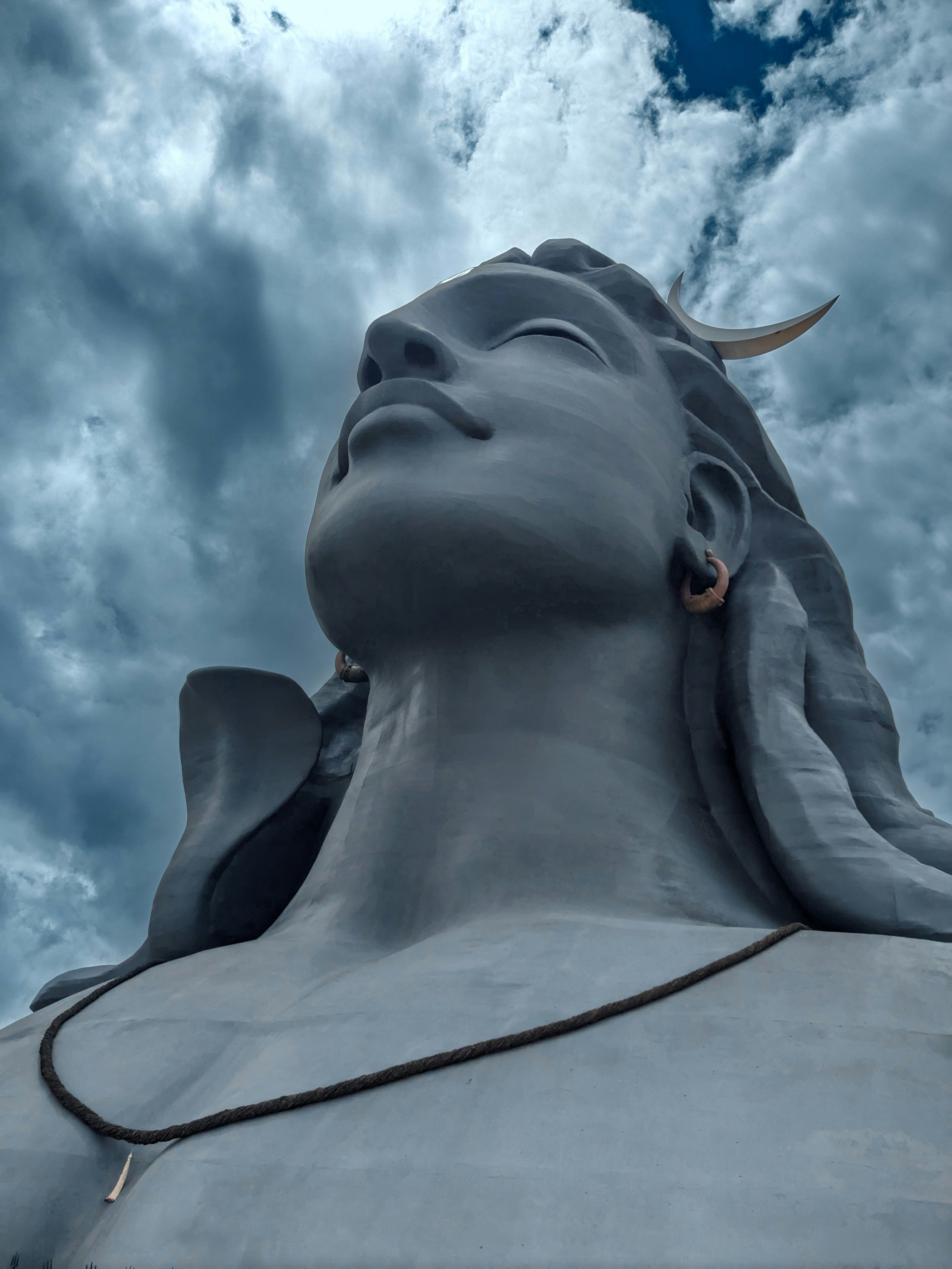 a close up of a statue with clouds in the background