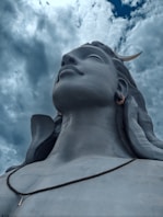 a close up of a statue with clouds in the background