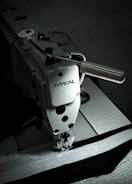 Industrial sewing machine stitching polypropylene bag closing thread.