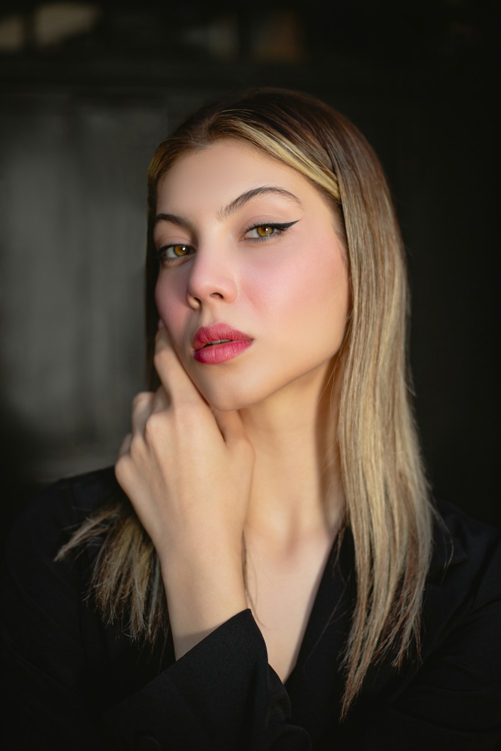 a woman is posing for a picture with her hand on her chin