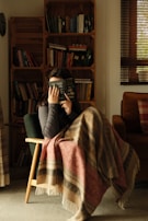 A person reading a book in a cozy corner.