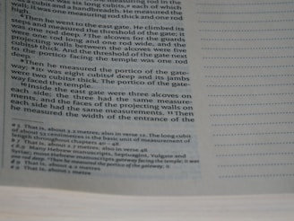 A close-up of a page from a book with printed text, mainly describing measurements and architectural details. The text appears in a structured format, possibly indicating a passage from a religious or historical document, with footnotes or references at the bottom.
