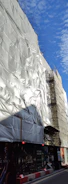 Wide shot of a commercial building with waterproofing membranes being installed.