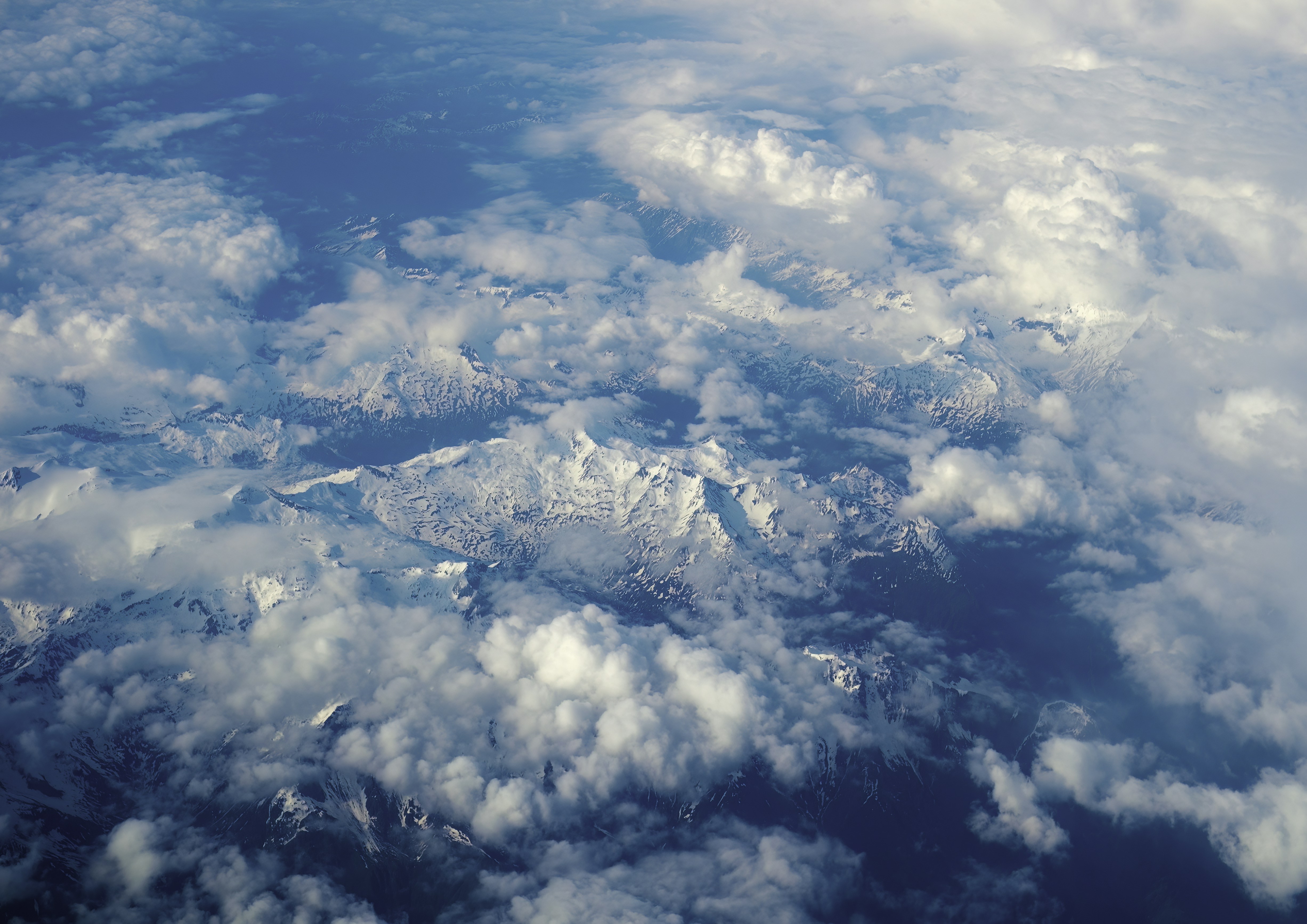 a view of a mountain range from an airplane, Flying over the clouds and mountains