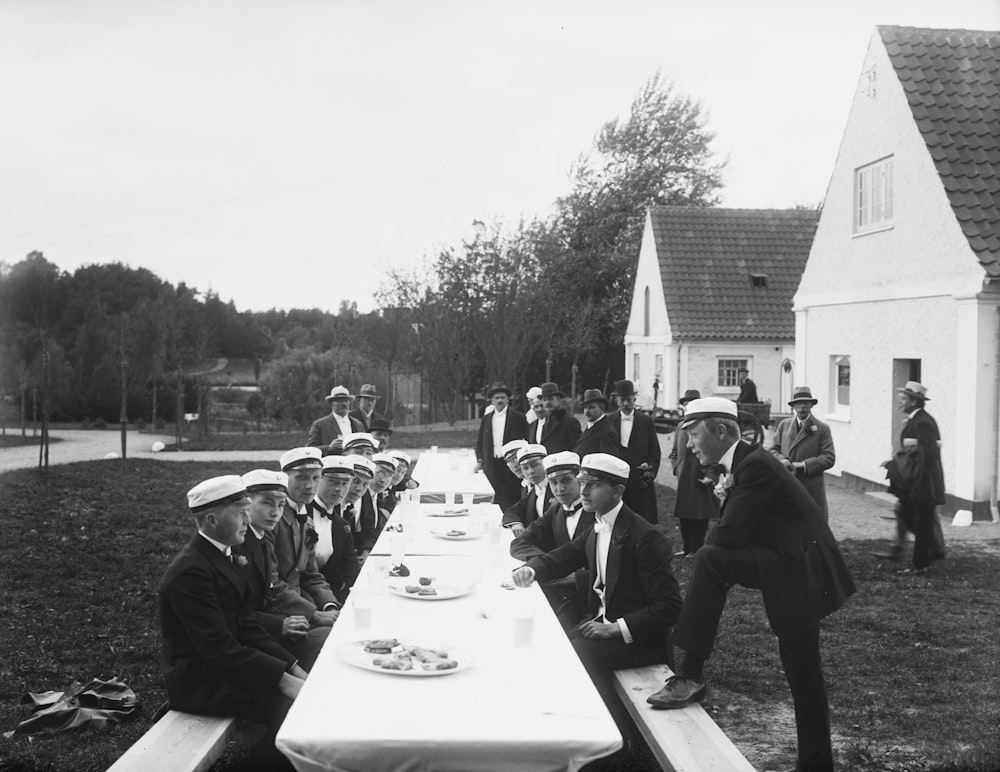 a group of men sitting at a long table