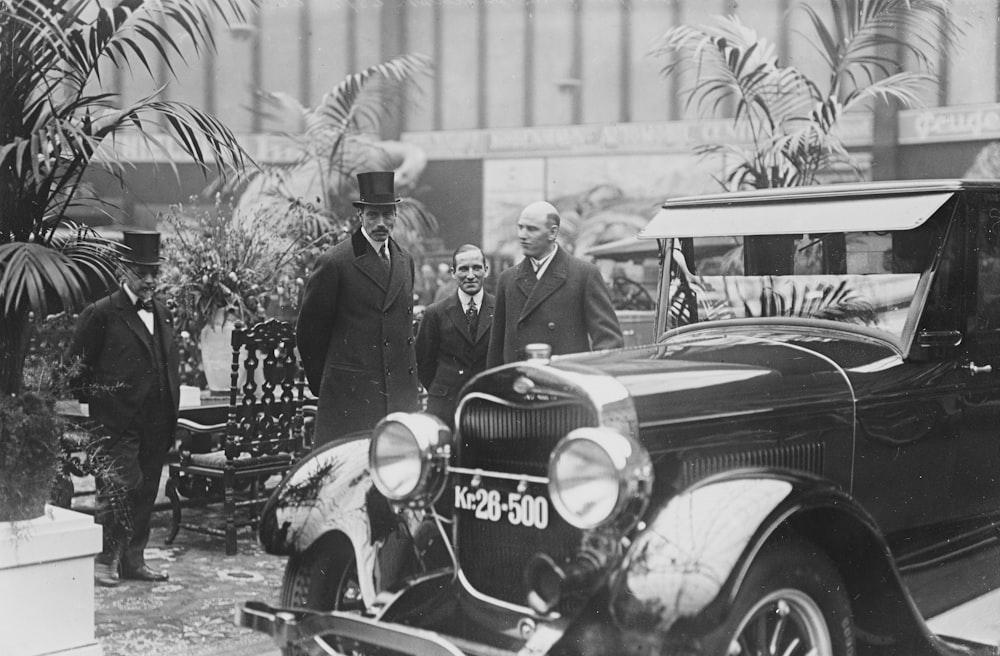 a group of men standing around a car