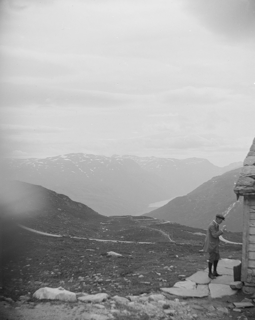 a man standing on top of a mountain next to a building