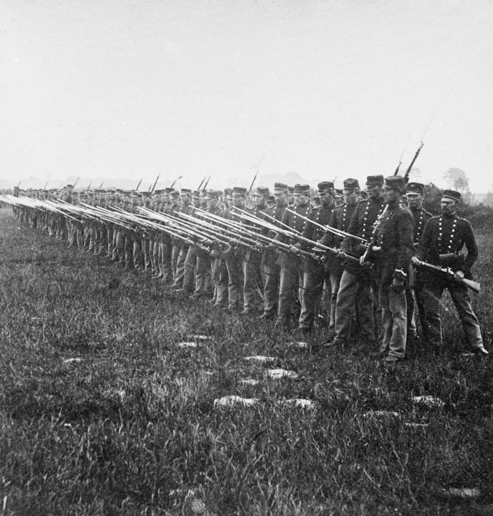 a group of men standing next to each other in a field