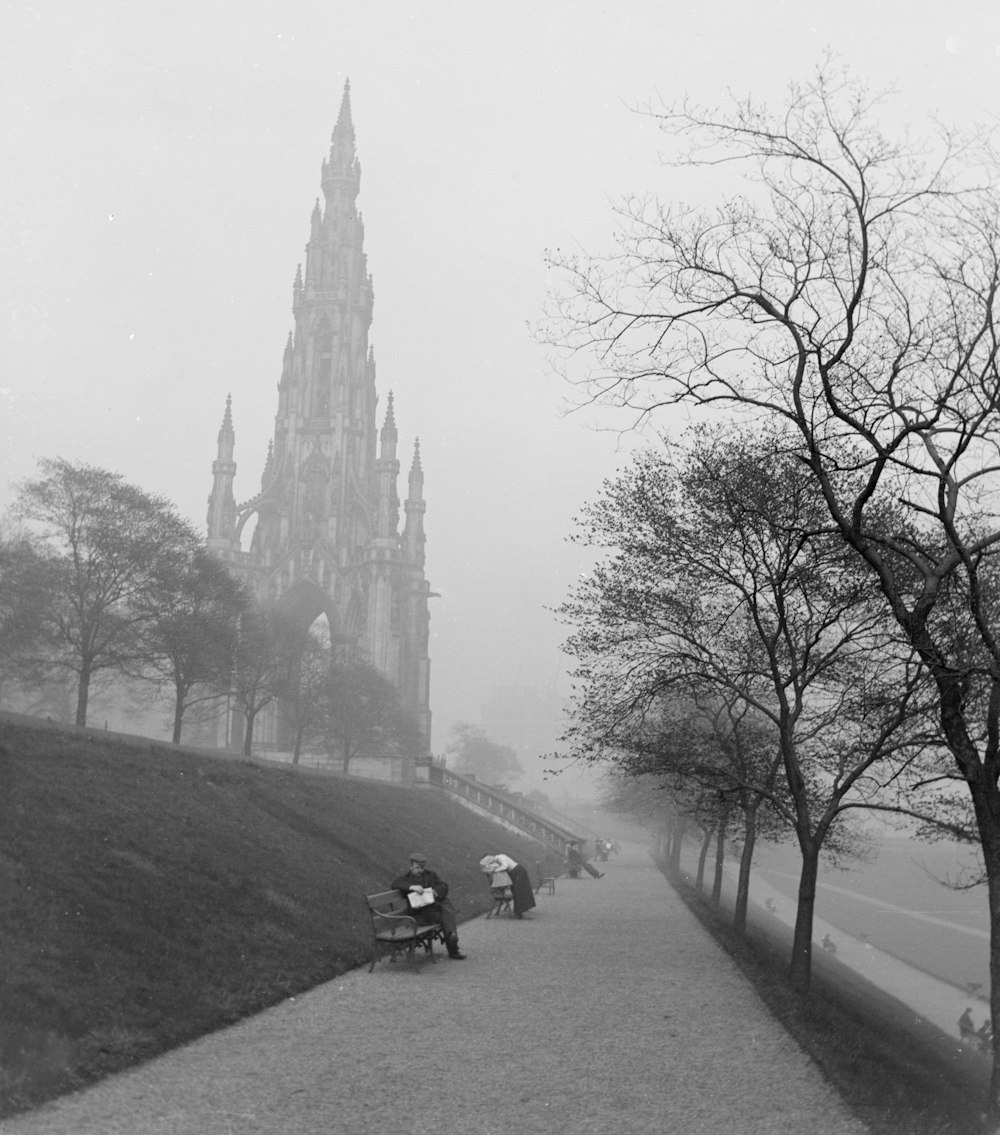 a black and white photo of people sitting on a bench