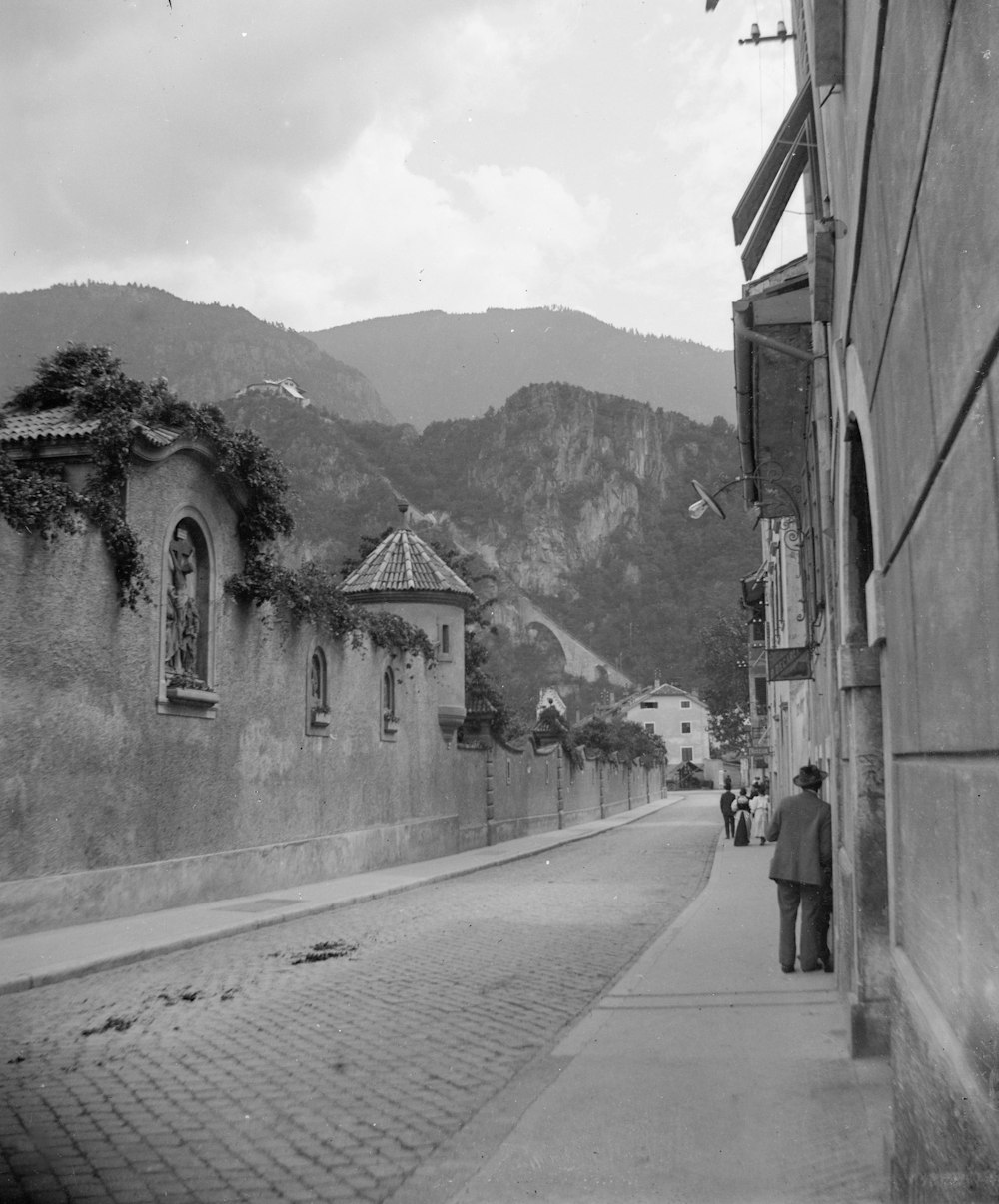 a black and white photo of people walking down a street