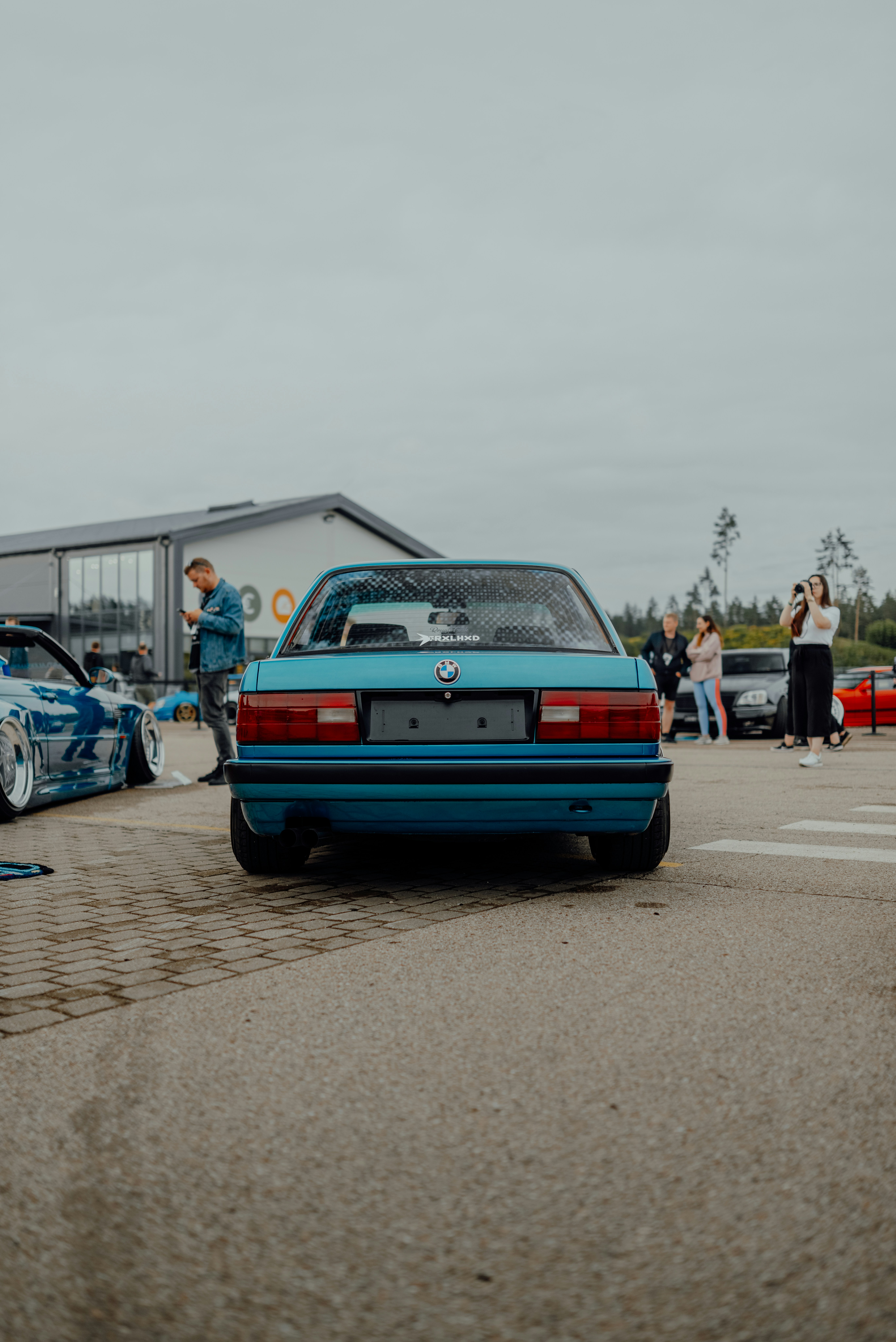 a blue car parked in a parking lot next to other cars