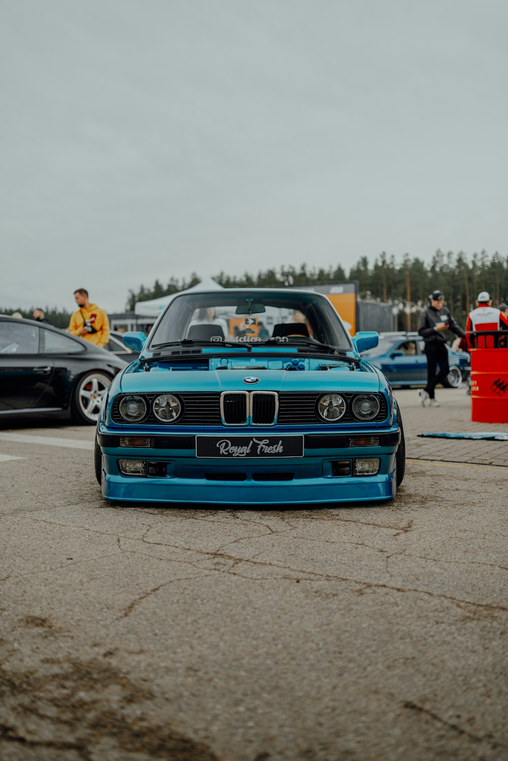 a blue car parked in a parking lot next to other cars