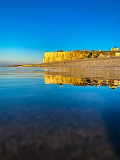 A serene coastal village in the UK bathed in golden sunset light.
