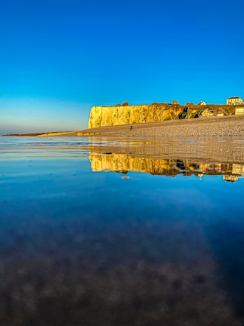 A serene coastal village in the UK bathed in golden sunset light.