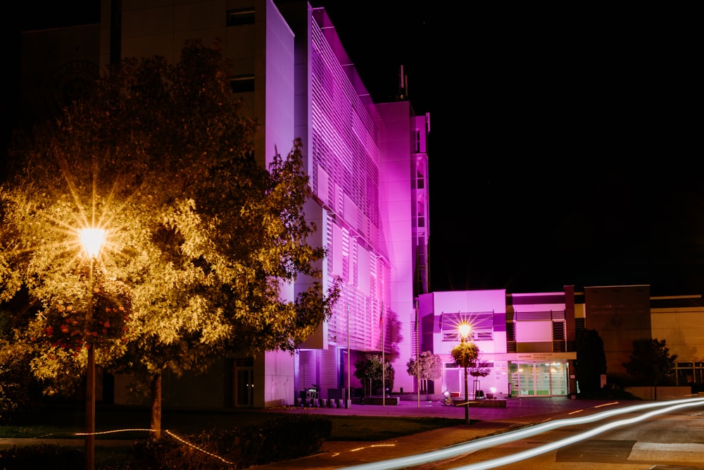Un edificio iluminado con luz púrpura por la noche