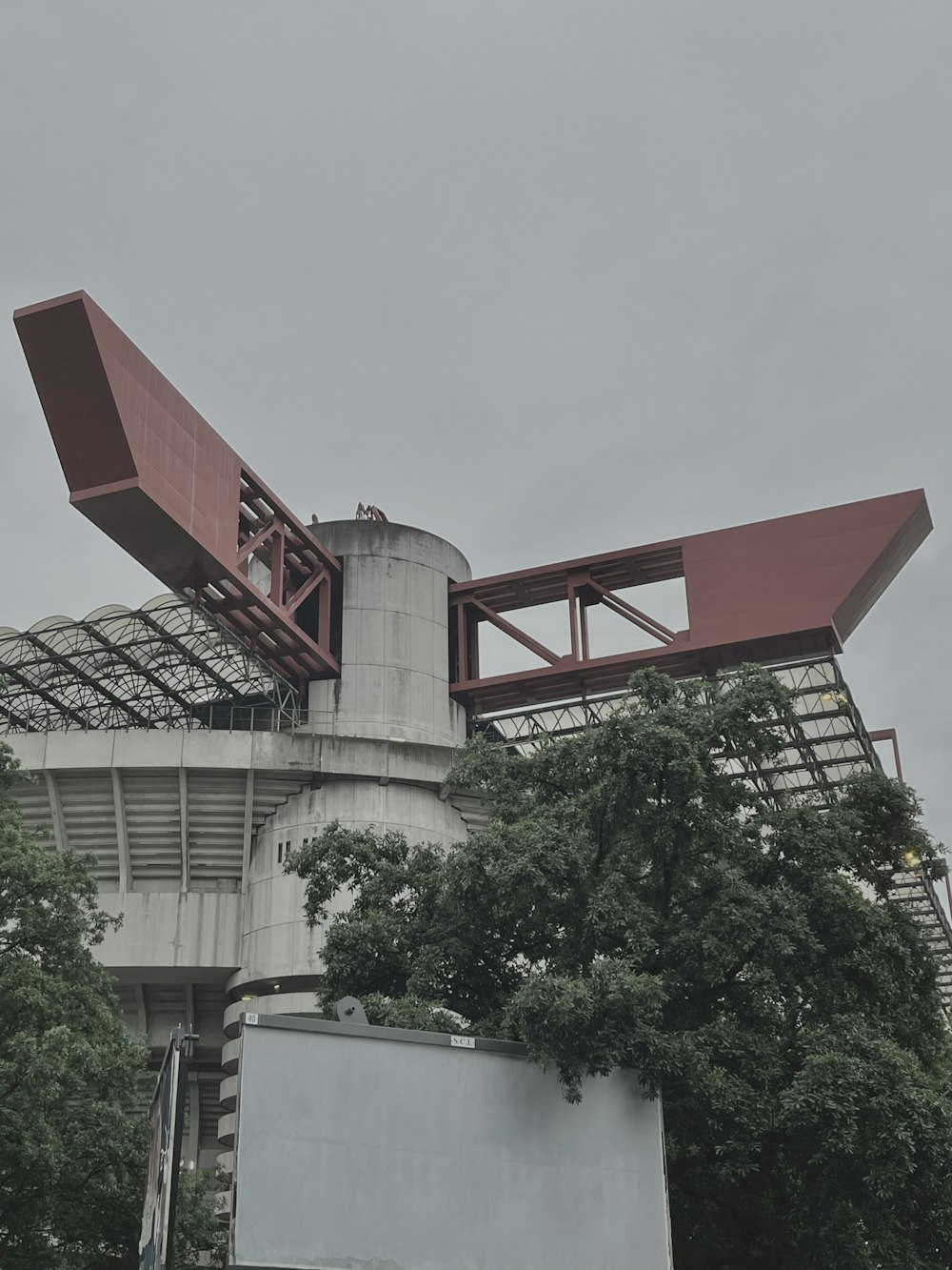 a tall building with a giant red object on top of it