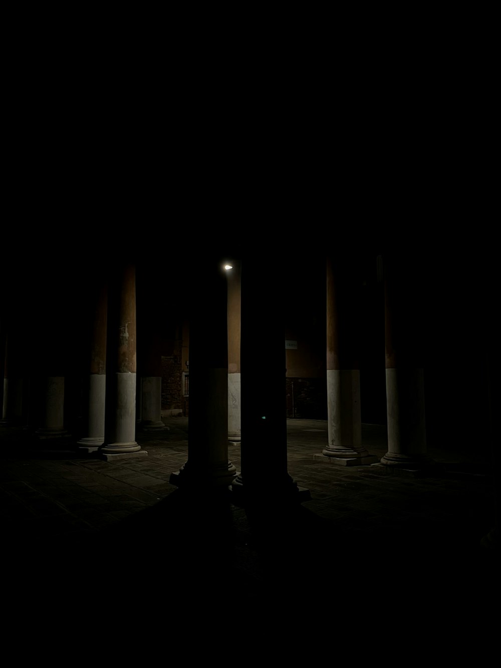 a dark room with columns and a street light