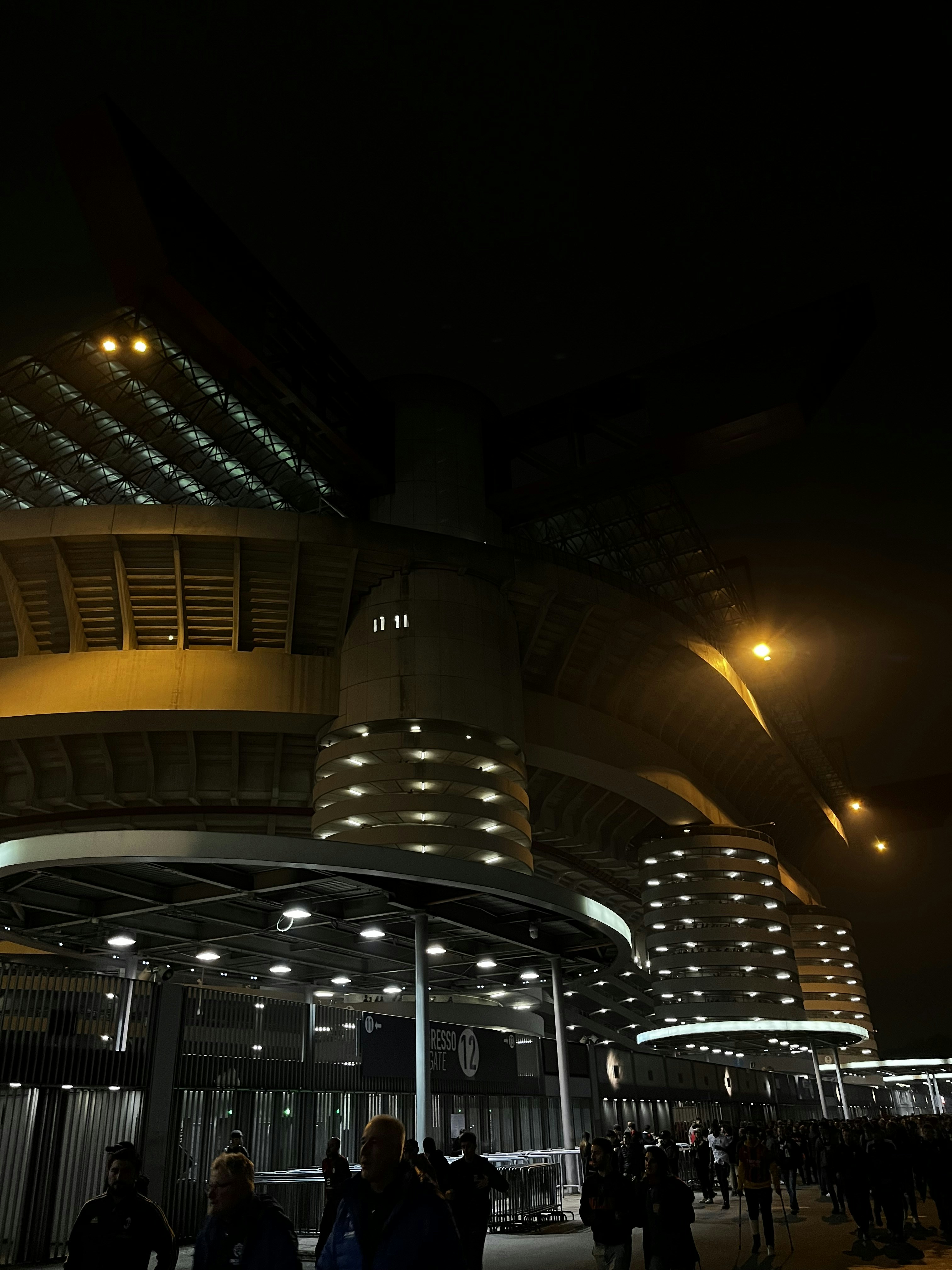 a group of people standing outside of a building at night