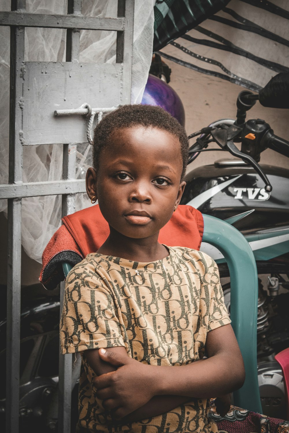 a young boy standing in front of a motorcycle