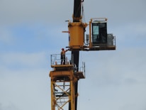 Close-up of a certified crane operator in safety gear controlling a crane.