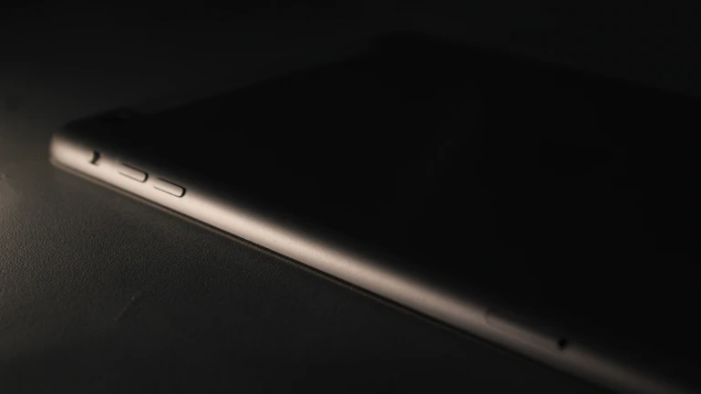 Close-up of a sleek blaumann android device glowing softly on a wooden desk.