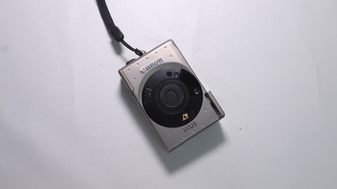 a camera attached to a cord on a white surface,