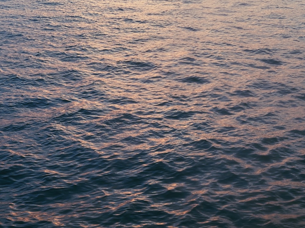 a large body of water with a boat in the distance