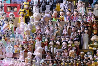 A collection of various figurines and dolls, including traditional Chinese-style characters and modern designs, is displayed on shelves. The figurines are dressed in colorful, ornate costumes, and some characters represent basketball players in jerseys. The scene is vibrant and slightly chaotic due to the vast array of items on display.