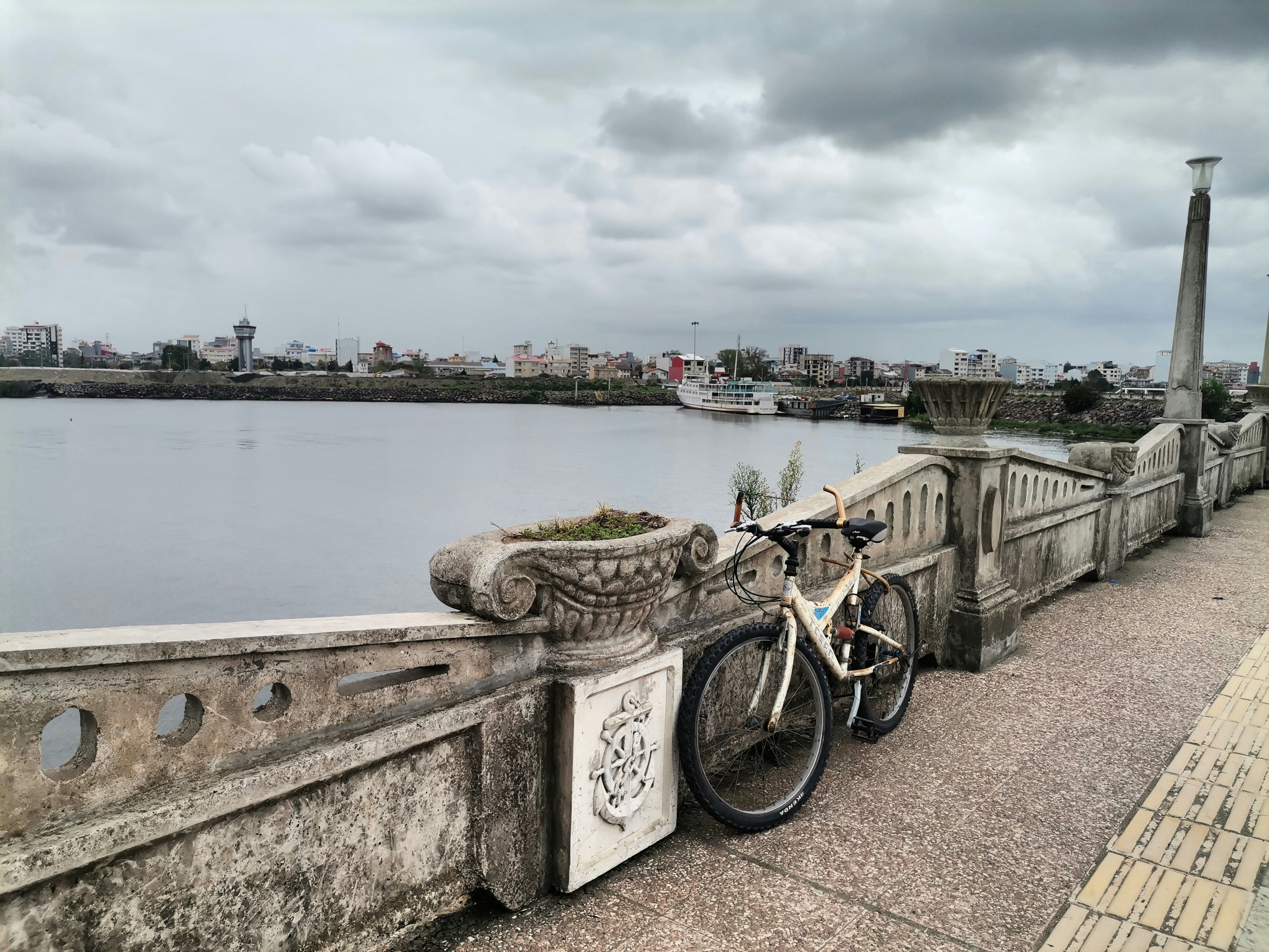 a bike parked on the side of a bridge next to a body of water