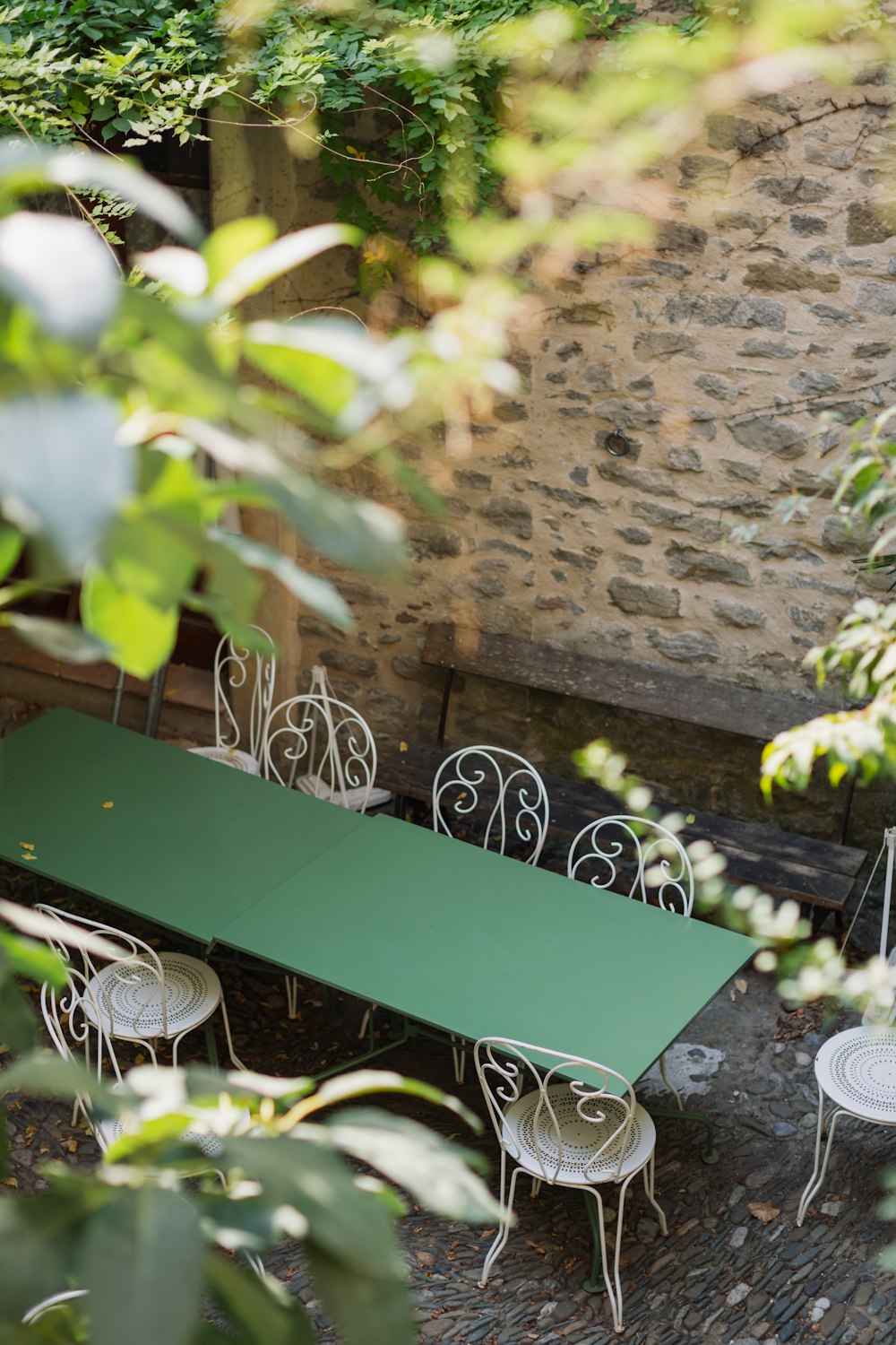 a green table and chairs in a courtyard