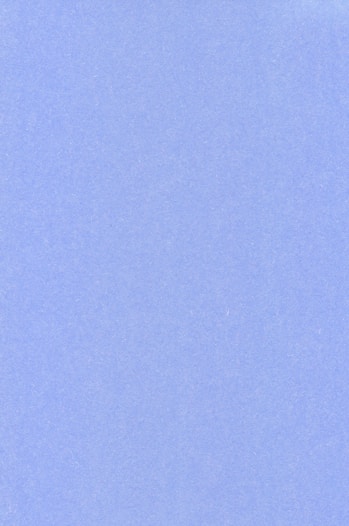an airplane flying in the sky with a blue background