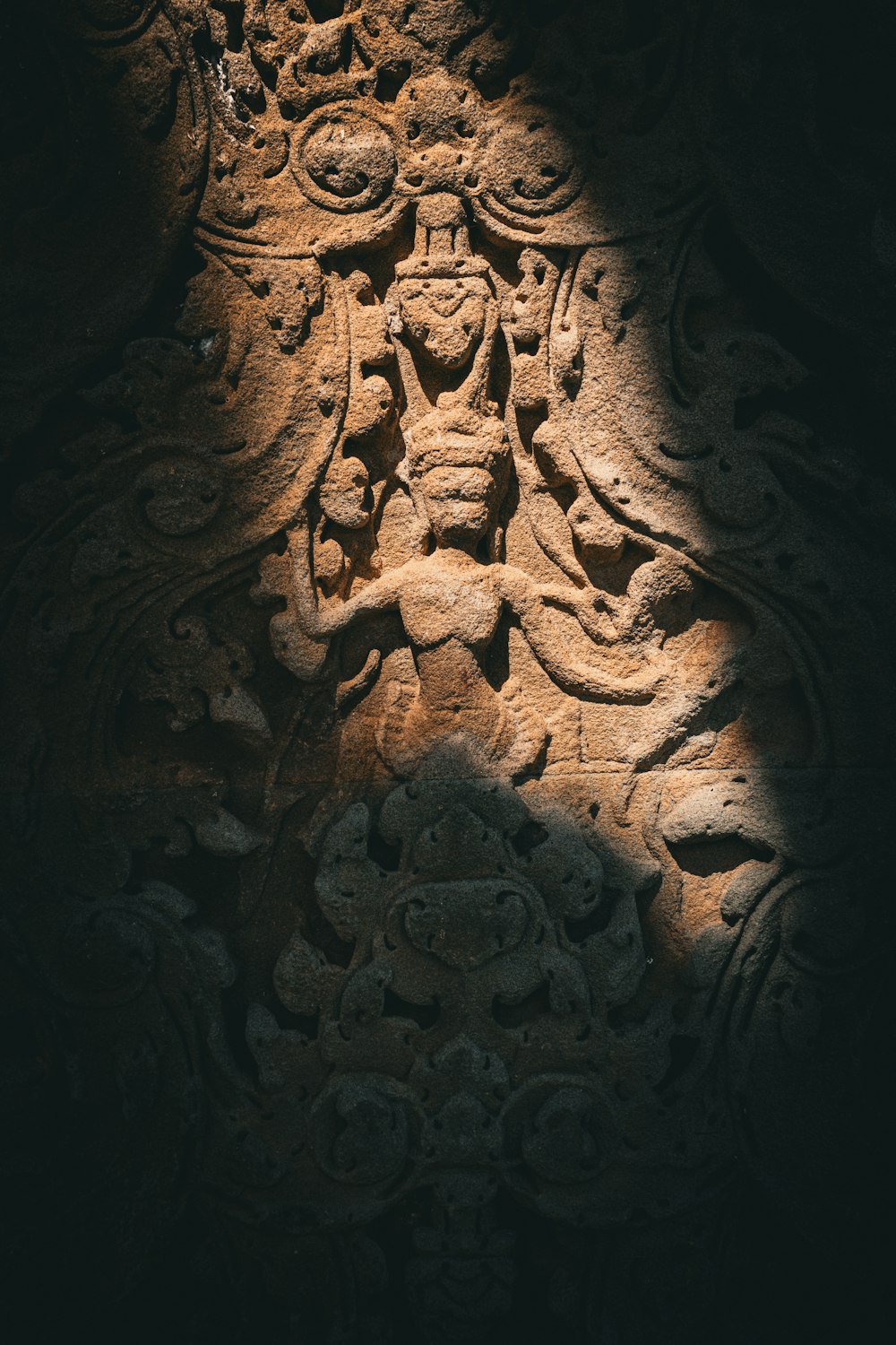 a stone carving of a buddha in a dark room