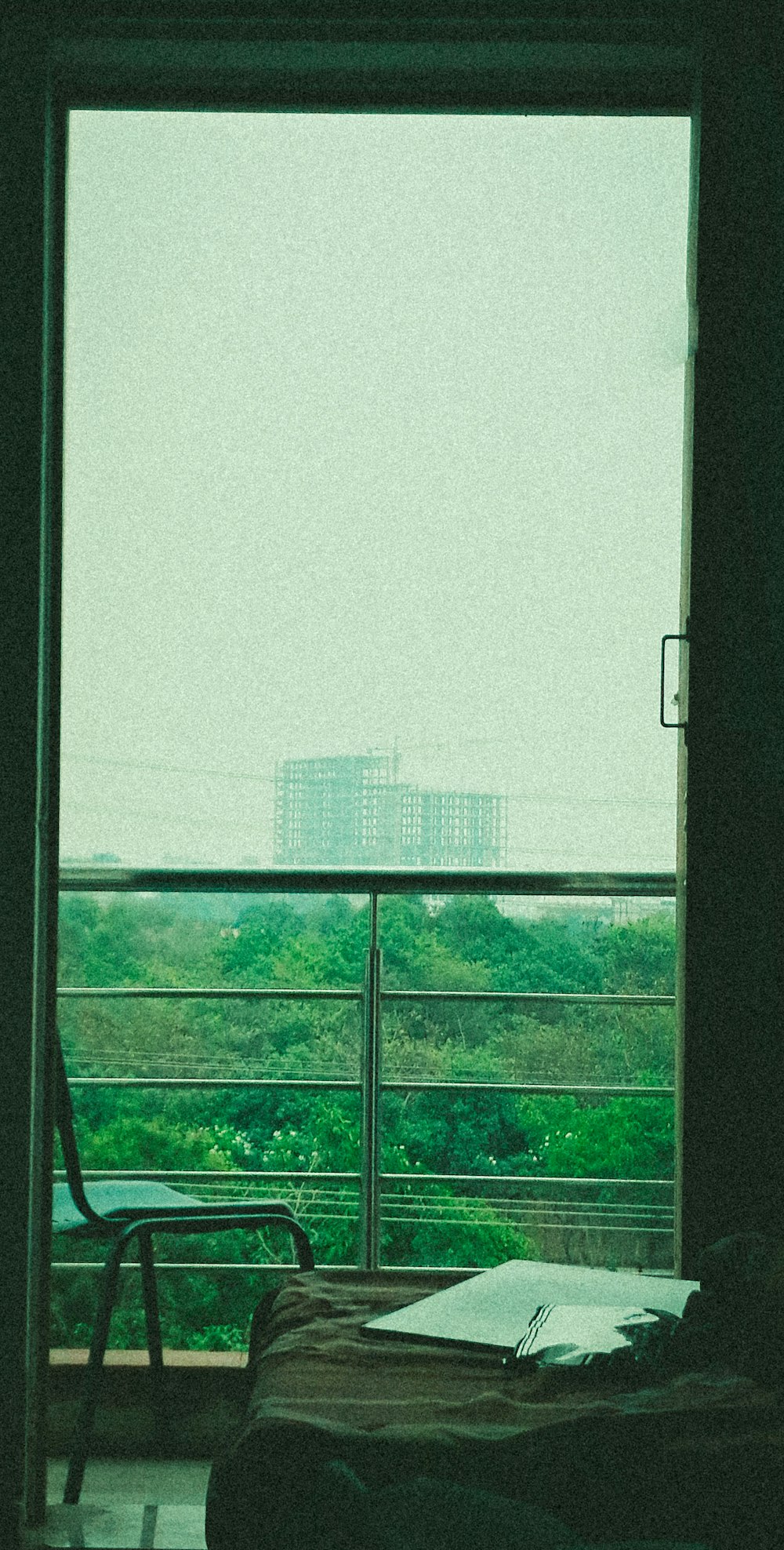 a bedroom with a view of a city outside the window