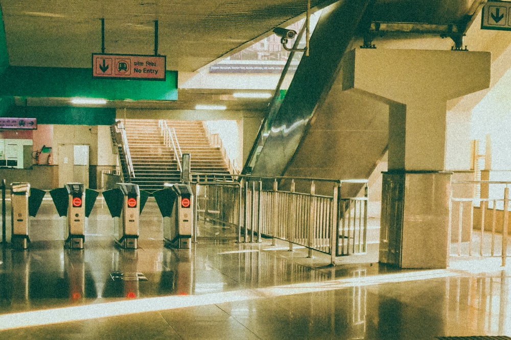 a row of luggage carts sitting next to an escalator