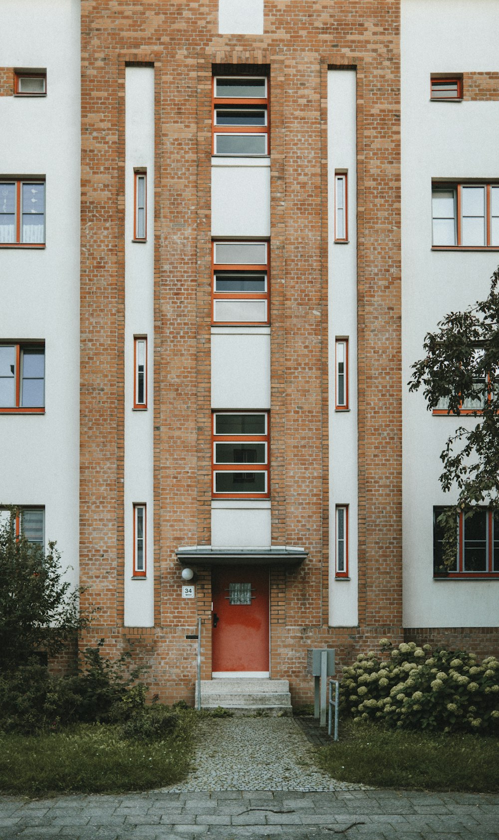 a tall brick building with a red door