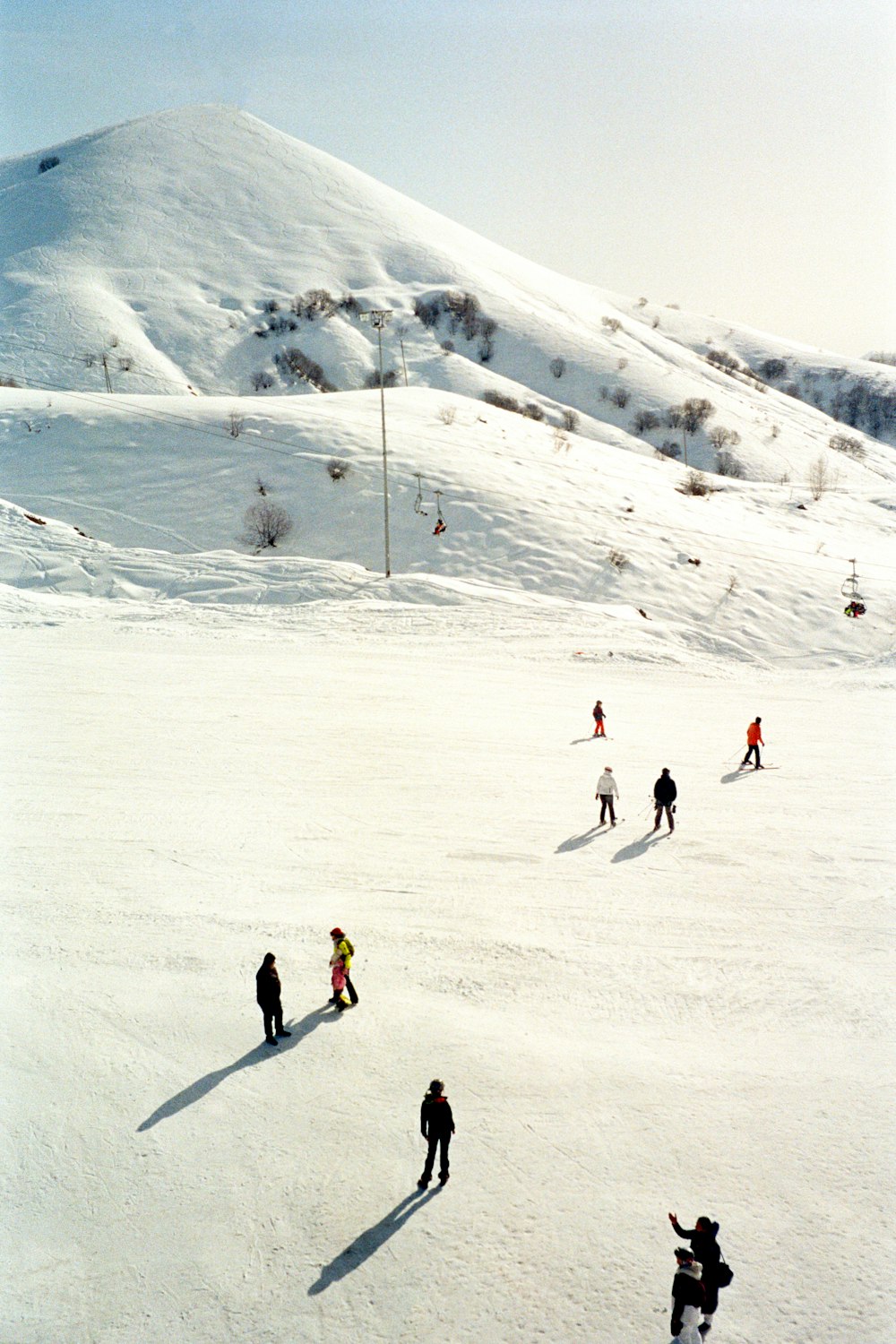 a group of people riding skis down a snow covered slope