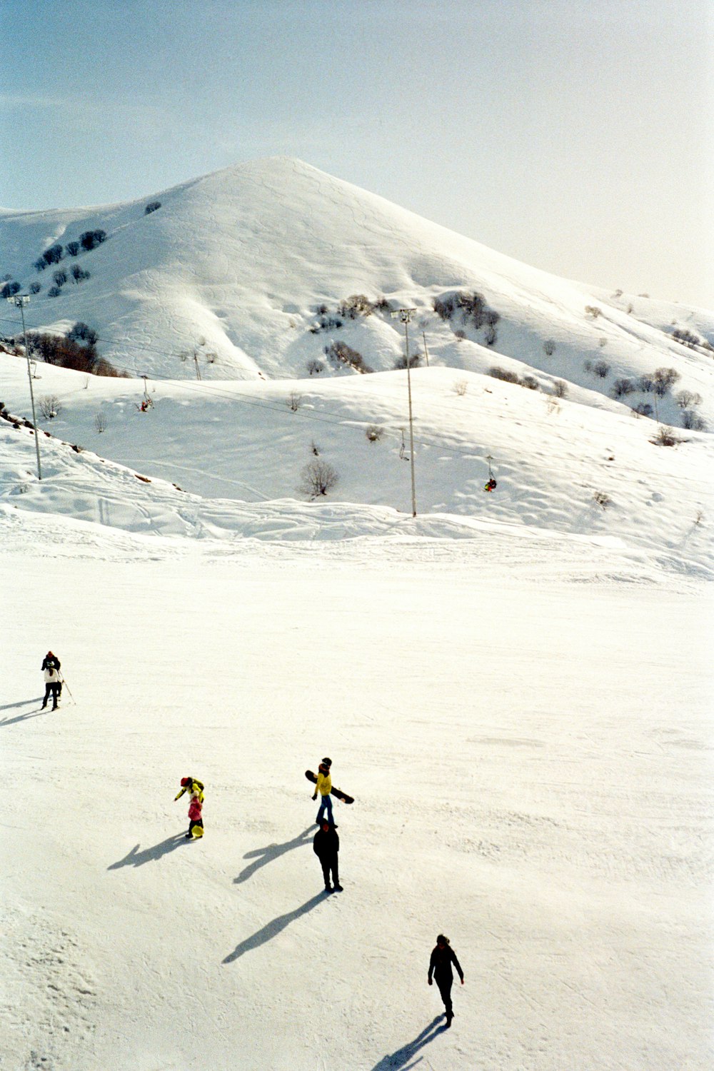 a group of people riding skis down a snow covered slope