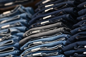 a pile of blue jeans sitting next to each other