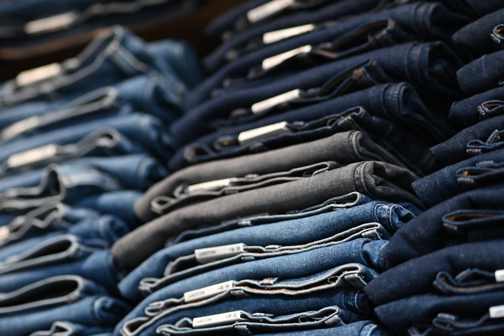 a pile of blue jeans sitting next to each other