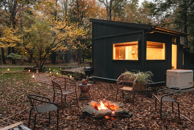 a small cabin in the woods with a fire pit